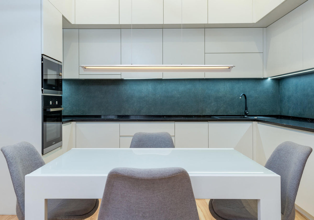 Mise en ambiance au-dessus d'une table blanche dans une cuisine moderne aux meubles laqués