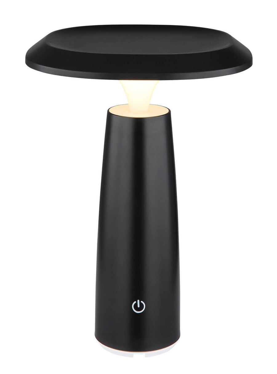 Lampe à poser noire mate allumée, vue de face sur fond blanc, lumière chaude.