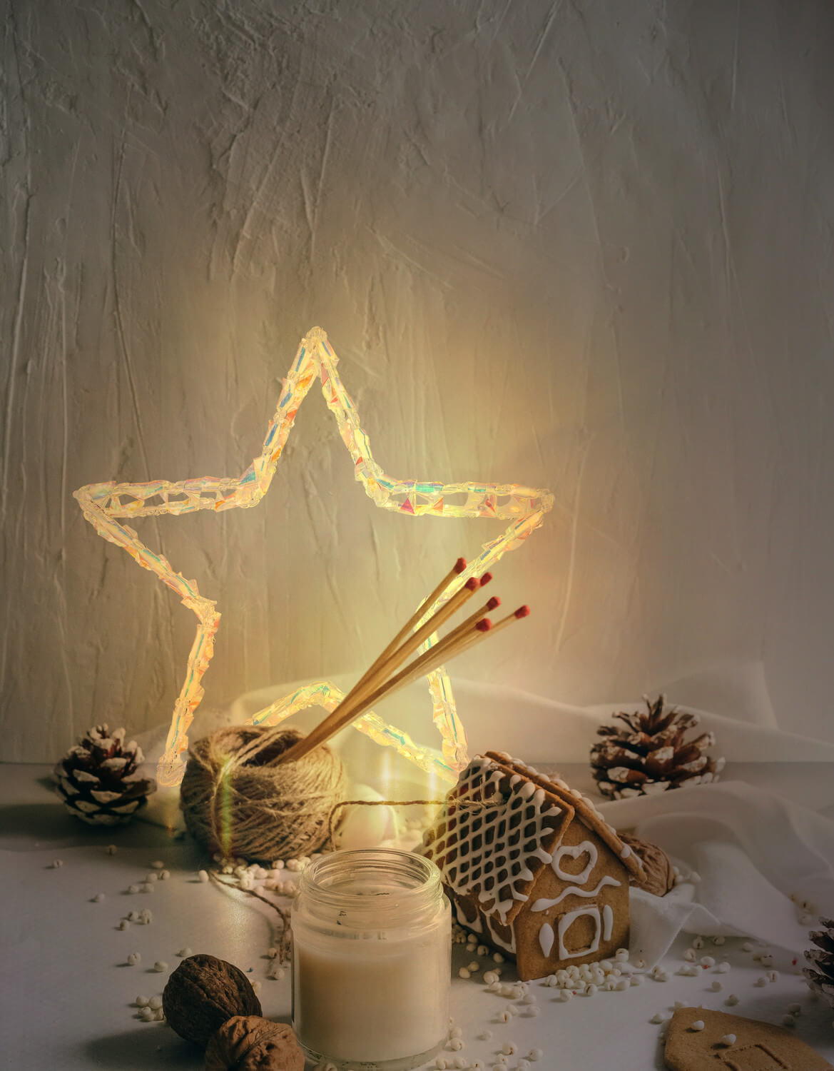 Mise en ambiance chaleureuse avec étoile lumineuse allumée parmi décorations de Noël