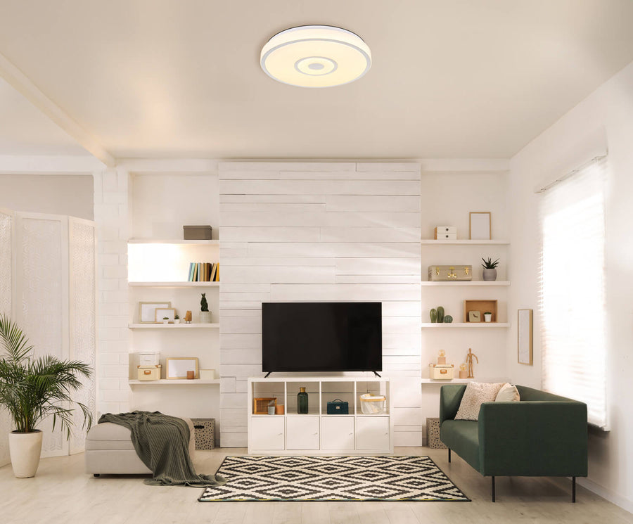 Plafonnier rond blanc installé au plafond d'un salon moderne
