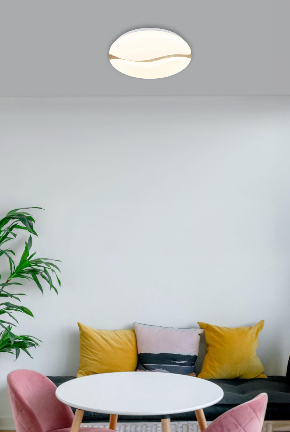 Plafonnier installé au plafond dans un salon moderne avec canapé, coussins et plante.