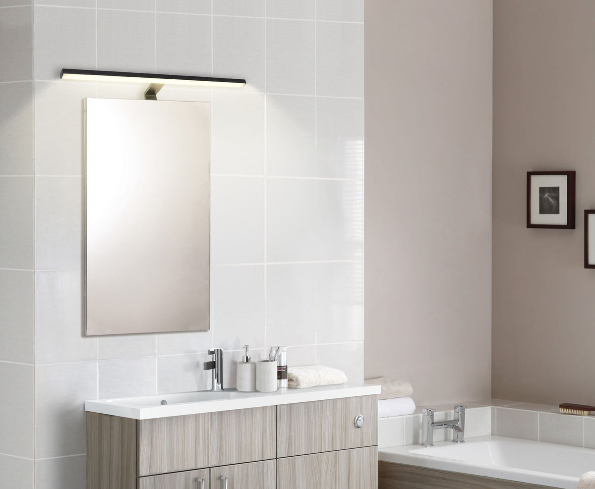 Mise en ambiance : applique murale noire installée au-dessus d'un miroir de salle de bain