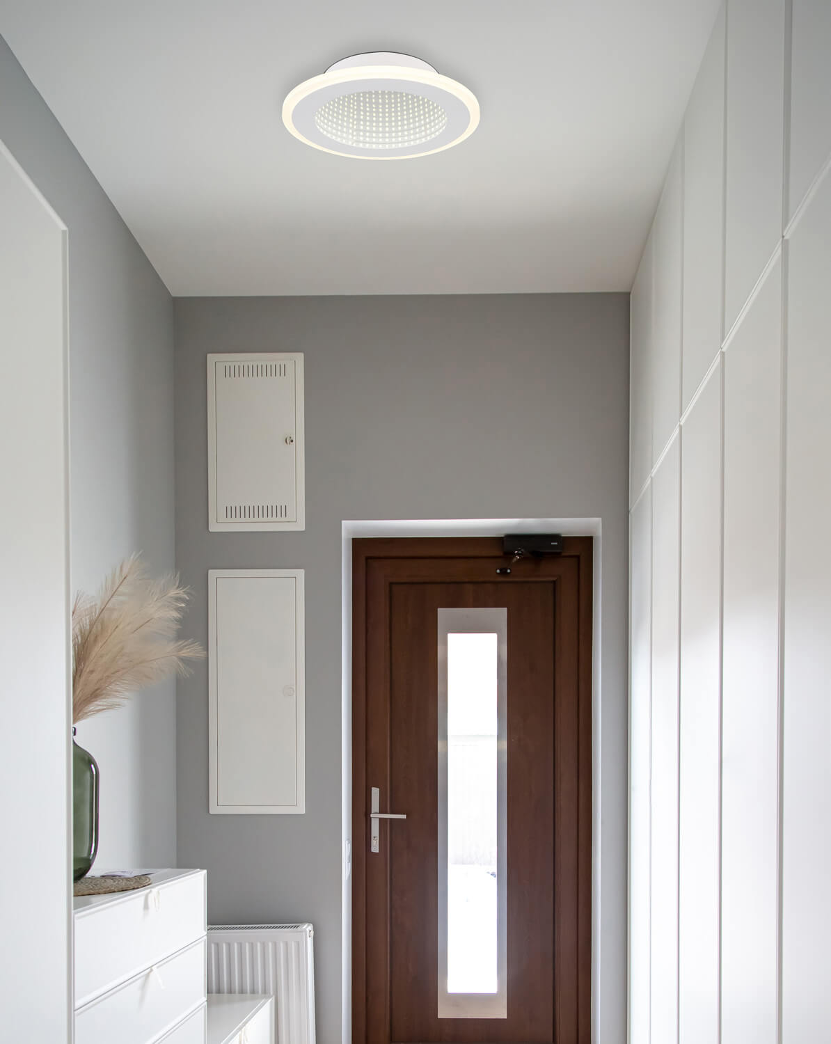 Mise en ambiance dans une entrée grise, plafonnier rond fixé au plafond