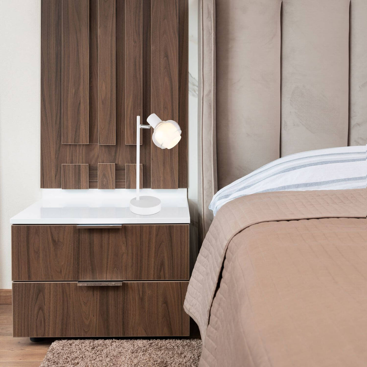 Mise en ambiance sur une table de chevet en bois verni près du lit