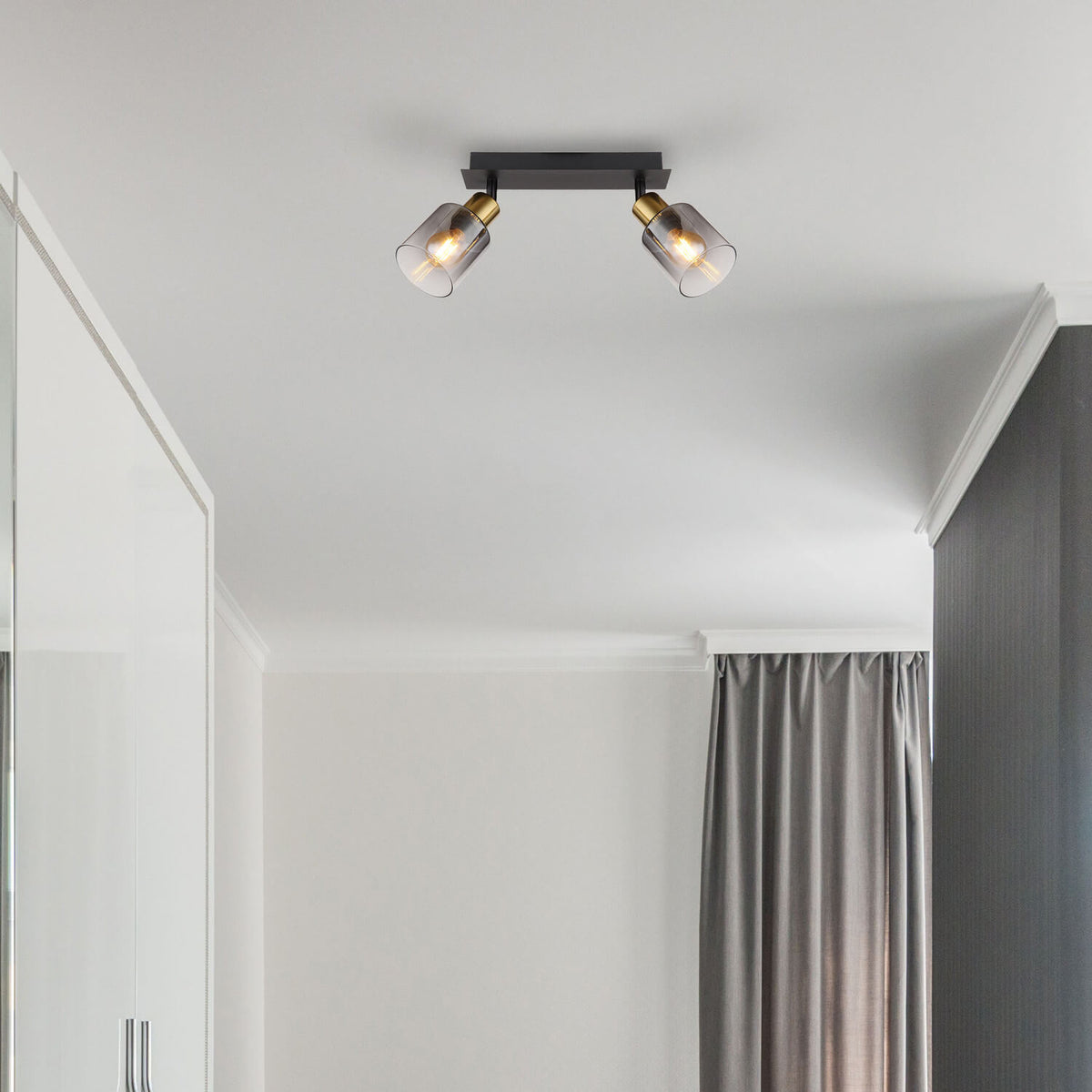Spot installé au plafond dans une chambre, éclairant la pièce avec une lumière chaleureuse.