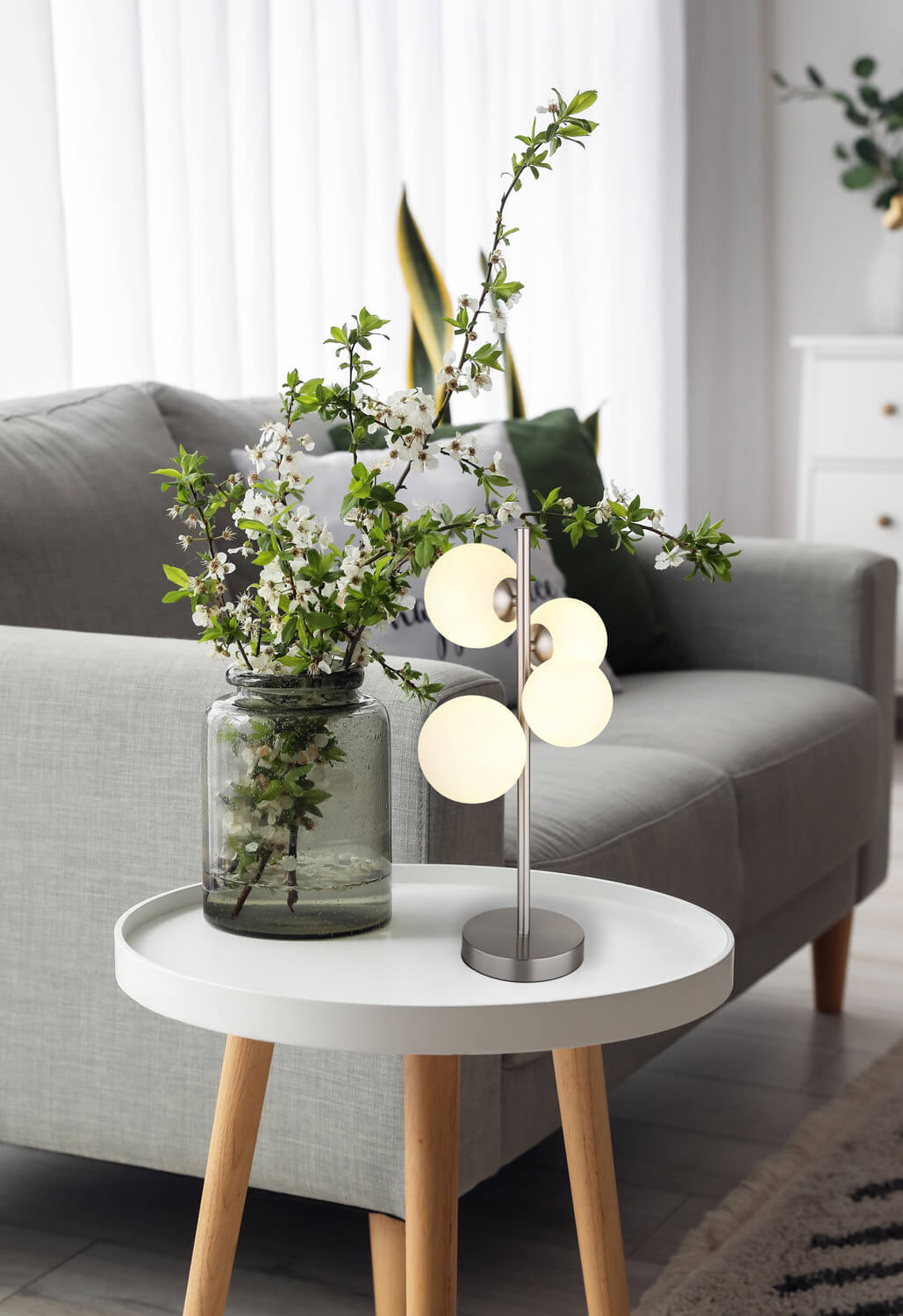 Mise en ambiance, lampe posée sur table basse près d'un vase fleuri