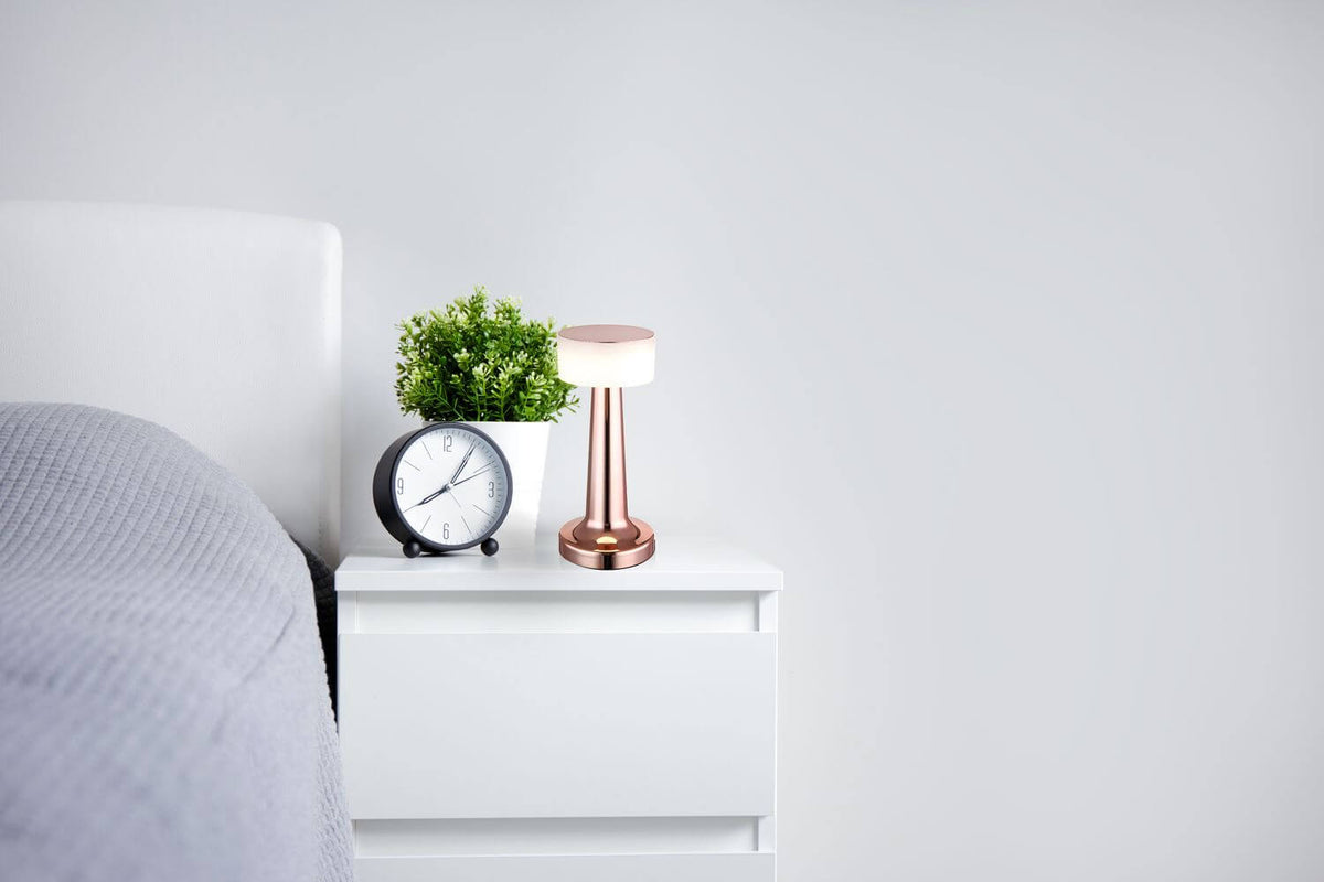 Mise en ambiance sur une table de chevet près d’un réveil
