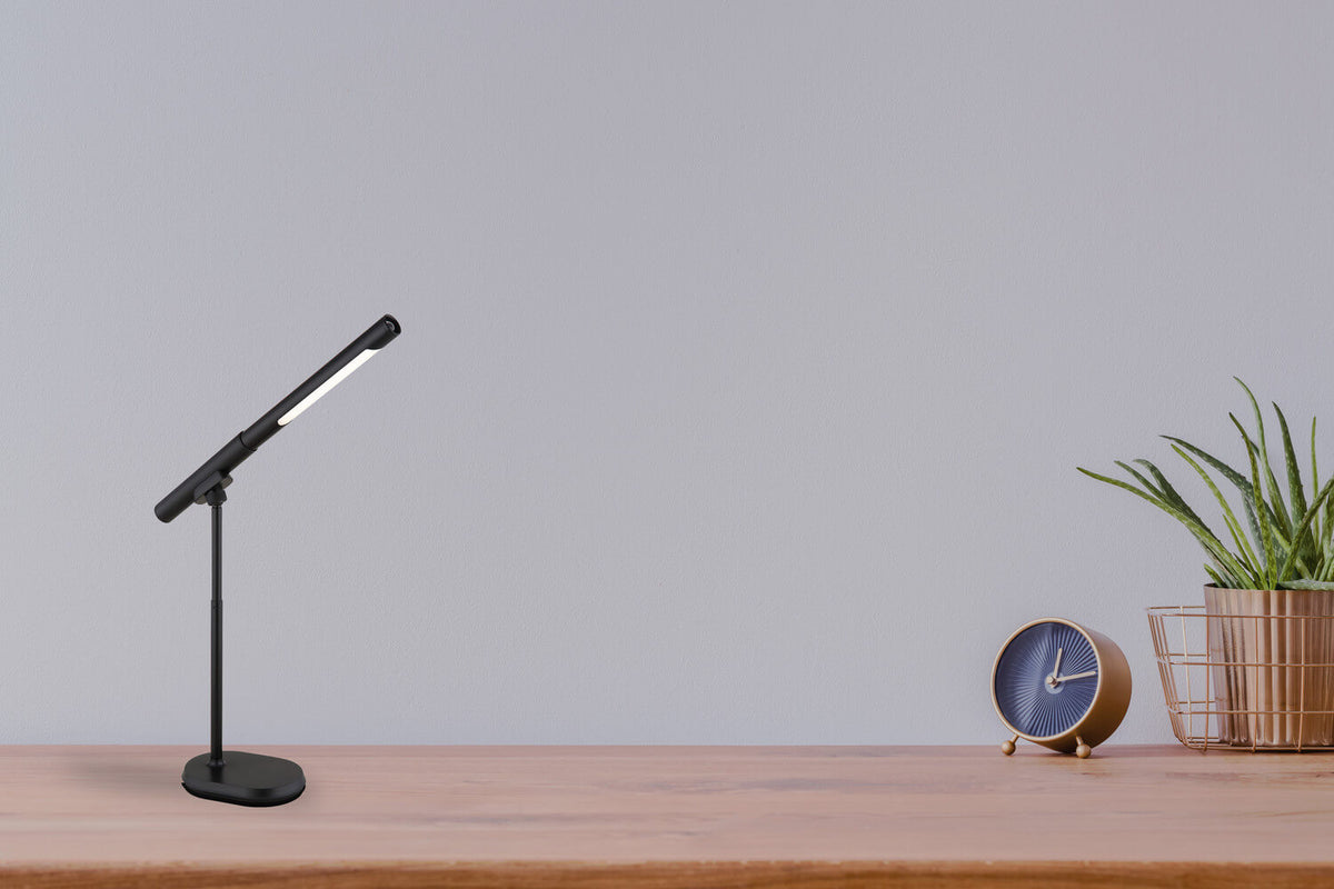 Mise en ambiance sur bureau en bois avec réveil doré et plante