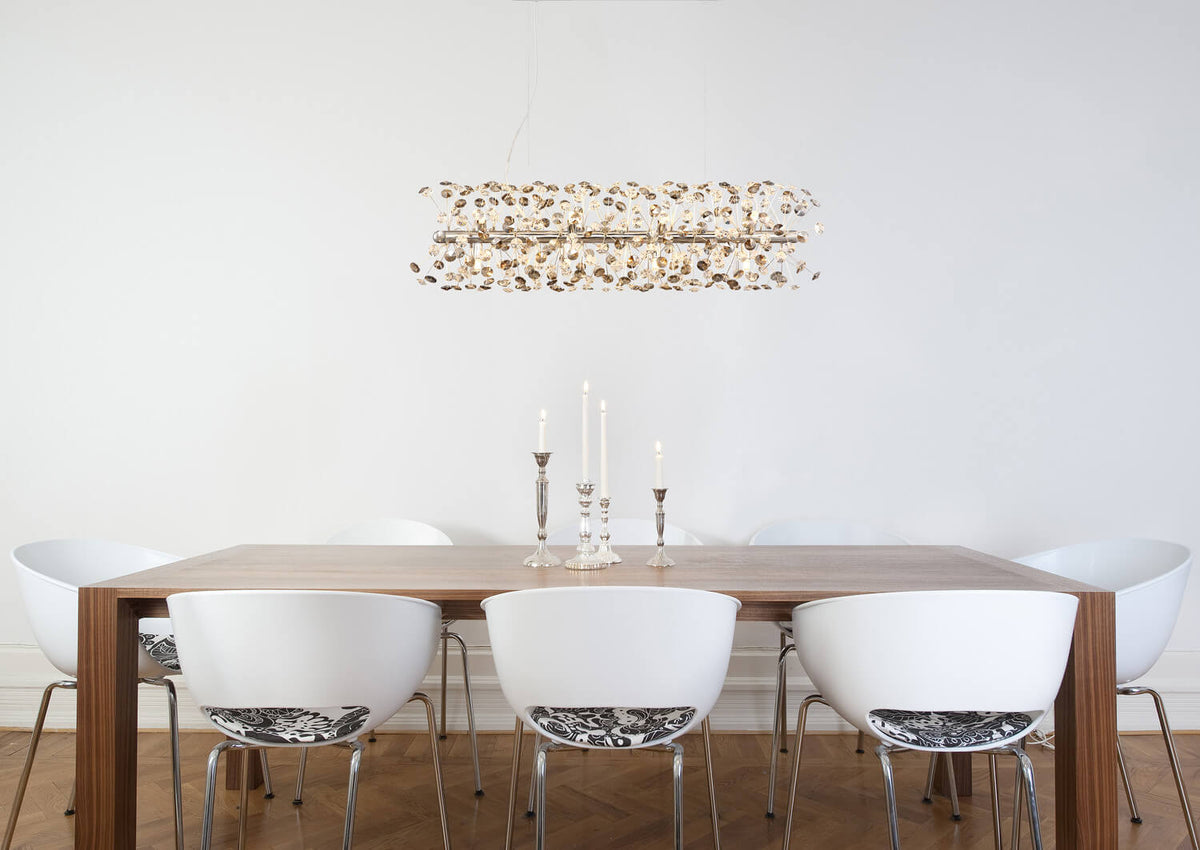 Mise en ambiance du luminaire suspendu au-dessus d'une table à manger en bois clair