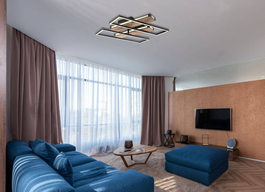 Luminaire allumé au plafond dans un salon moderne avec canapé bleu et grandes fenêtres.