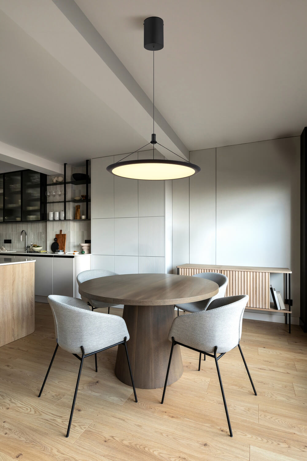 Mise en ambiance de la suspension allumée au-dessus d'une table ronde en bois clair