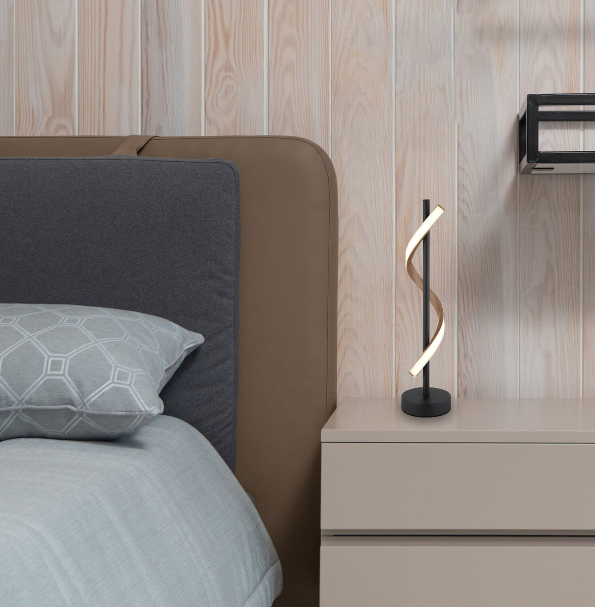 Mise en ambiance de la lampe allumée sur une table de chevet en bois clair