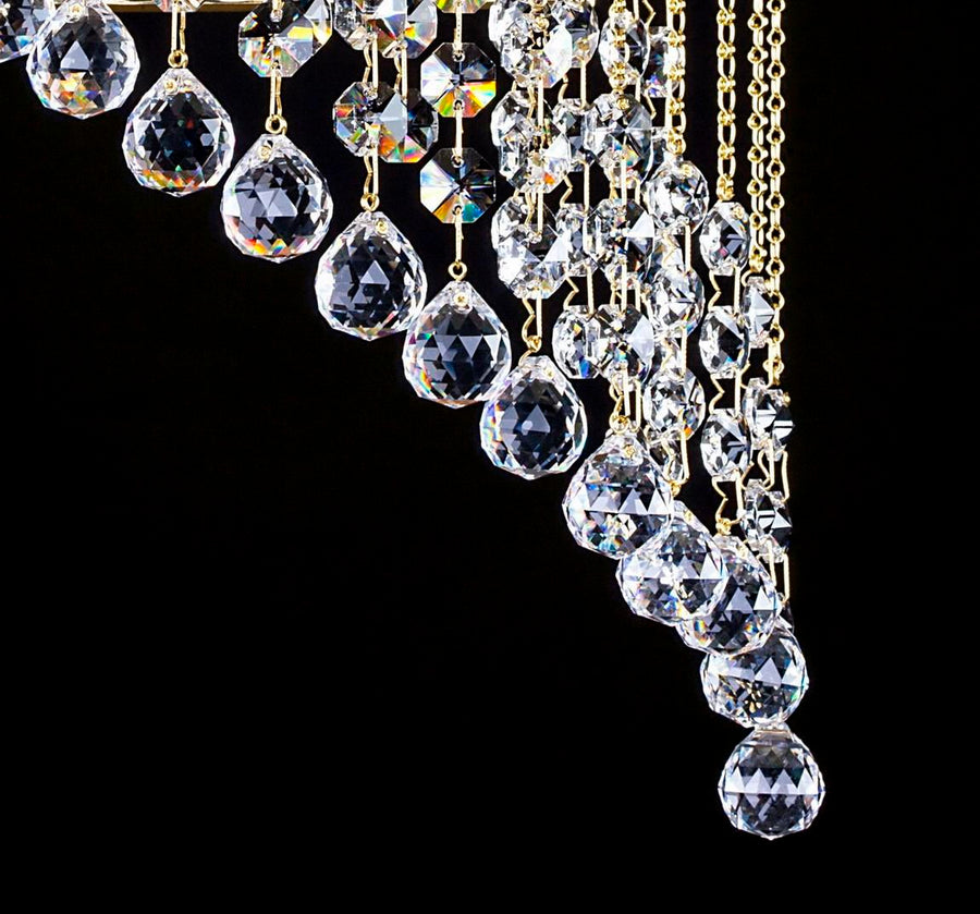Détail des gouttes de cristal taillé et chaînettes dorées de la cascade.