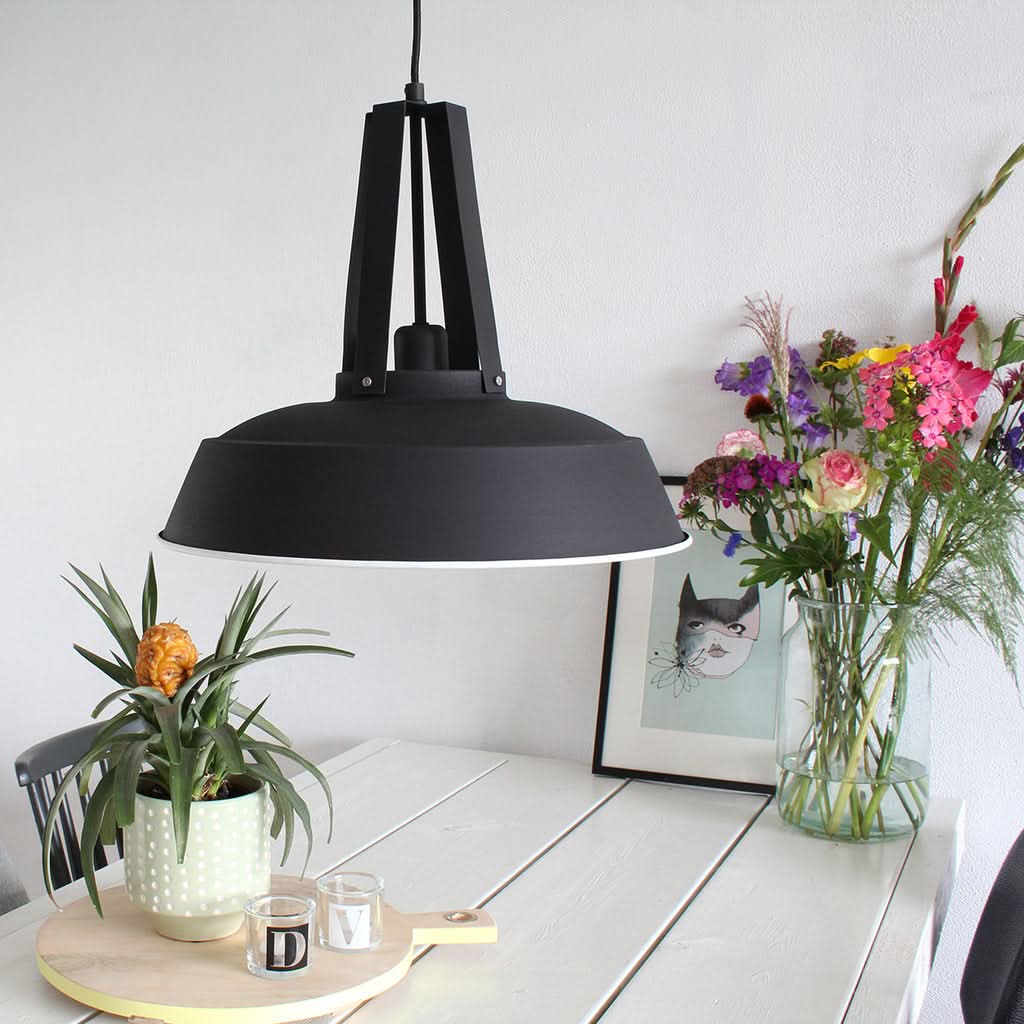 Suspension dôme noir au-dessus d'une console, ambiance intérieure chaleureuse | Designix