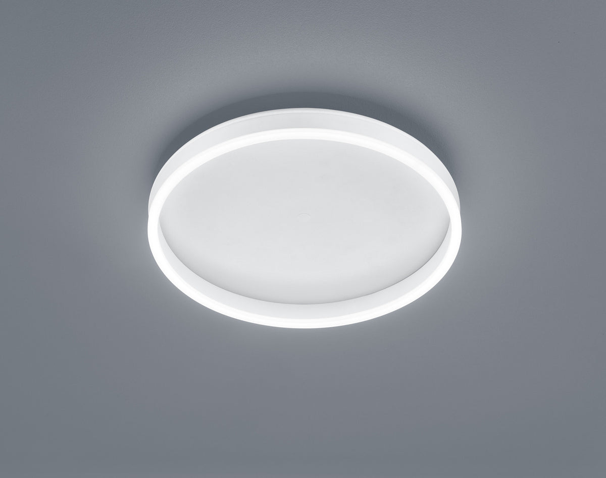 Plafonnier rond blanc vu de dessous, halo lumineux périphérique sur fond gris neutre
