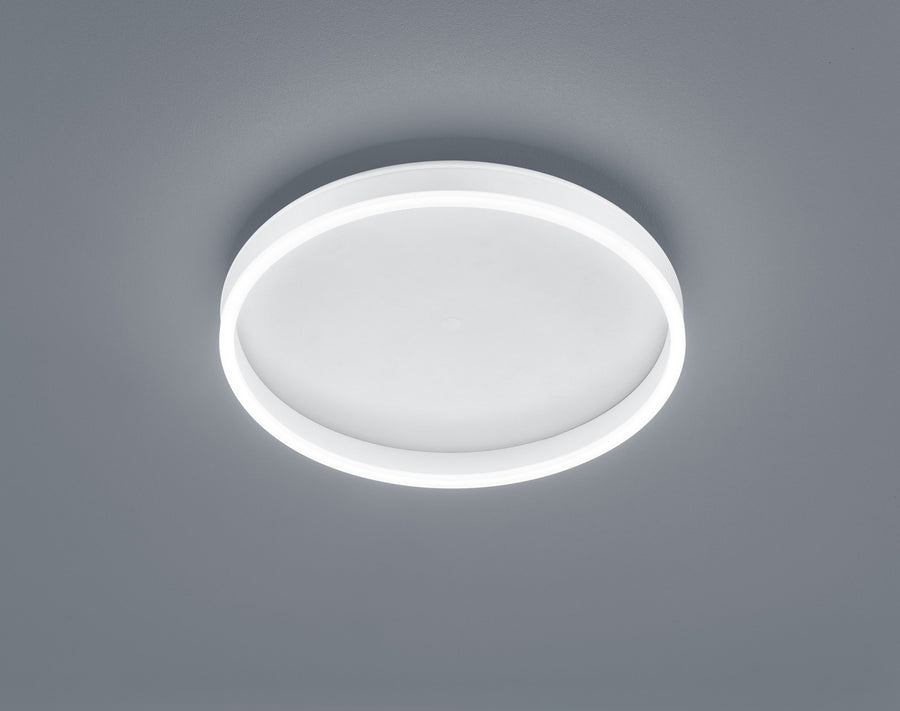 Plafonnier rond blanc vu de dessous, halo lumineux périphérique sur fond gris neutre