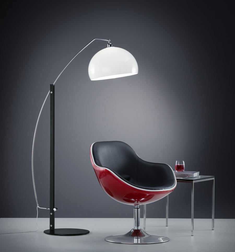 Vue de trois-quarts du lampadaire arc allumé près d'un fauteuil rouge