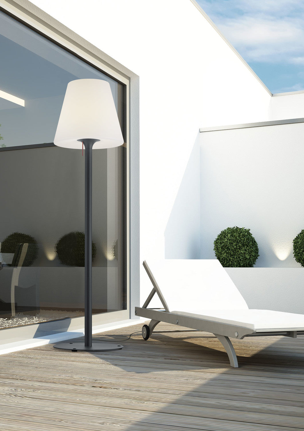 Vue rapprochée du lampadaire sur terrasse en bois, ombres et mobilier d'extérieur.