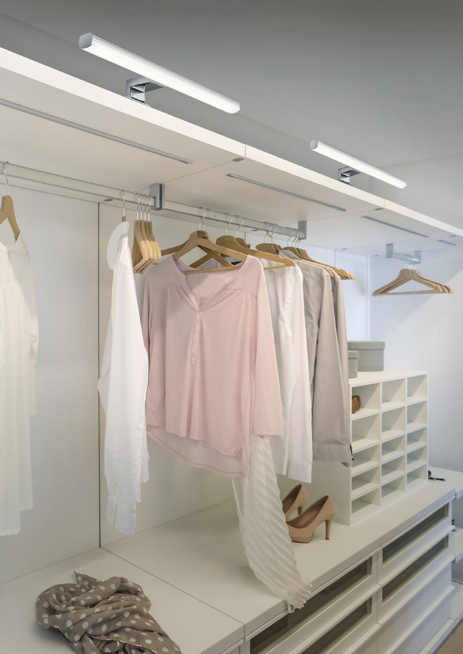 Vue rapprochée du bandeau lumineux éclairant chemises et blouses suspendues