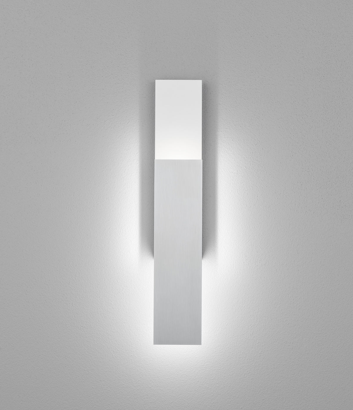 Détail de la barre verticale blanche éclairée par le bas sur fond de mur texturé