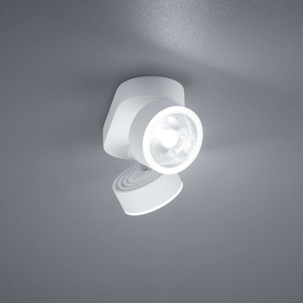 Détail de la finition blanche et de la lentille LED d'un projecteur orientable.