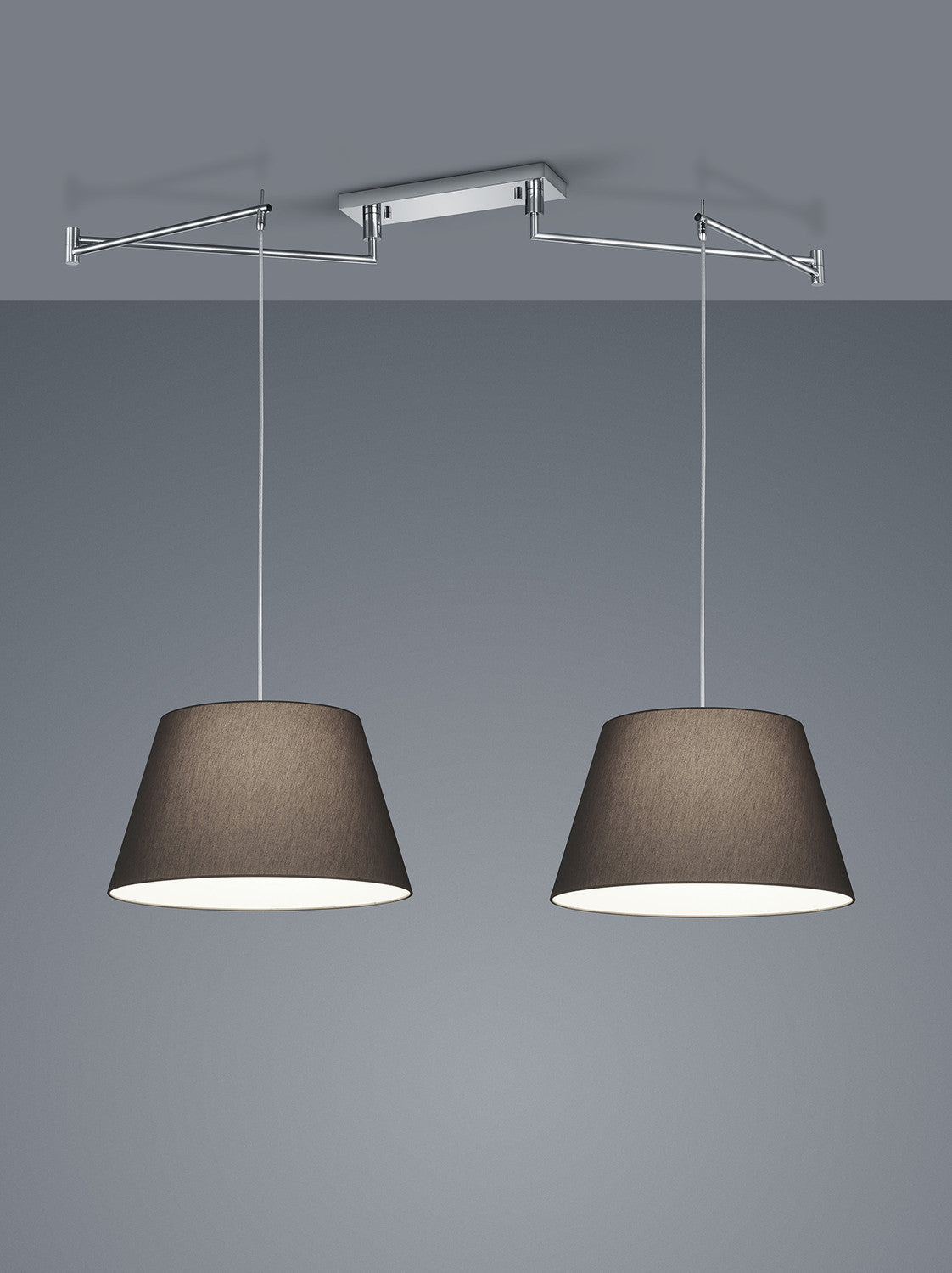 Vue rapprochée de la suspension deux lumières, structure chromée et abat-jours coniques en tissu.