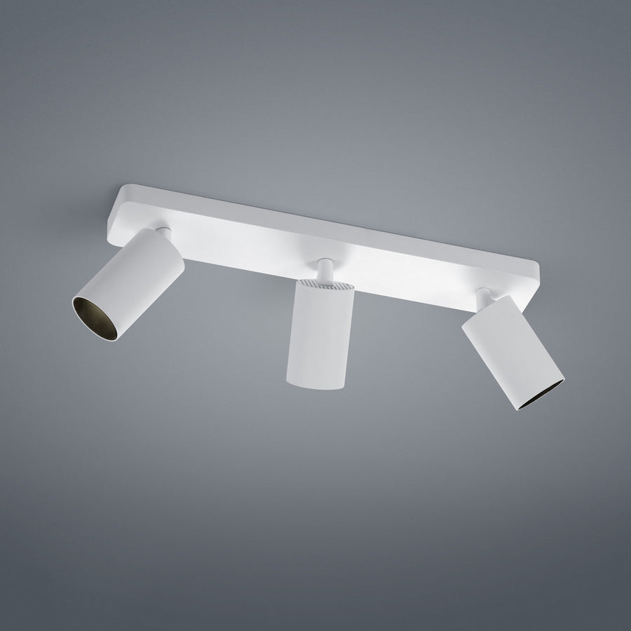 Plafonnier blanc à trois spots cylindriques orientables, fond gris neutre, vue de produit.