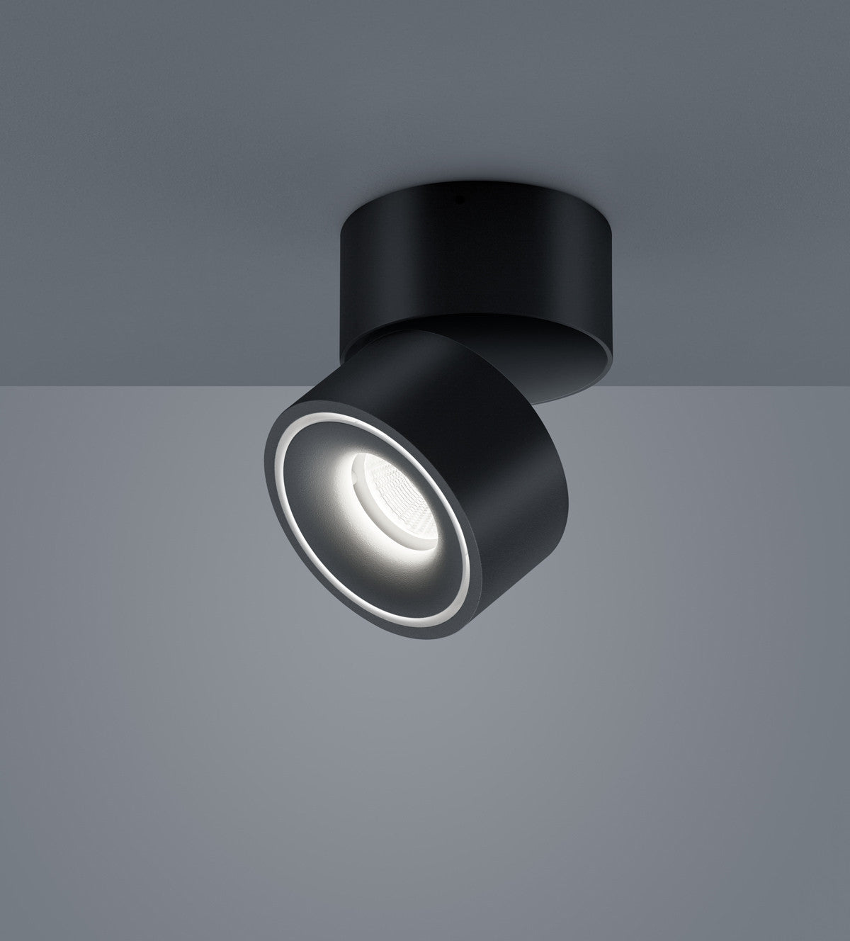 Plafonnier noir orientable vu de près, projecteur cylindrique incliné vers le bas