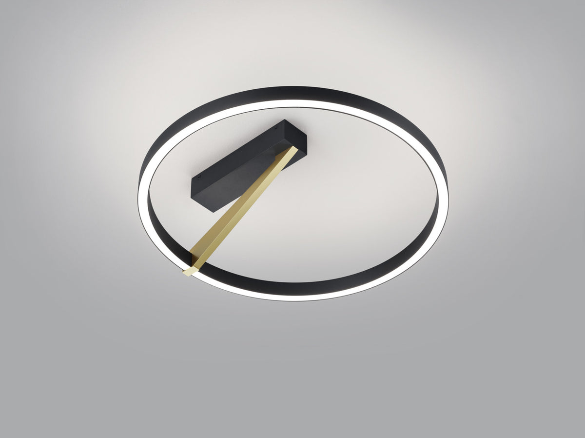 Vue de dessous du plafonnier rond noir, anneau LED allumé et bras doré diagonal