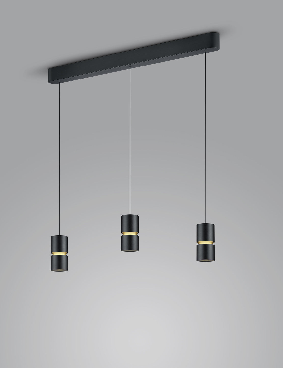 Trois cylindres noirs suspendus à une barre rectangulaire fixée au plafond