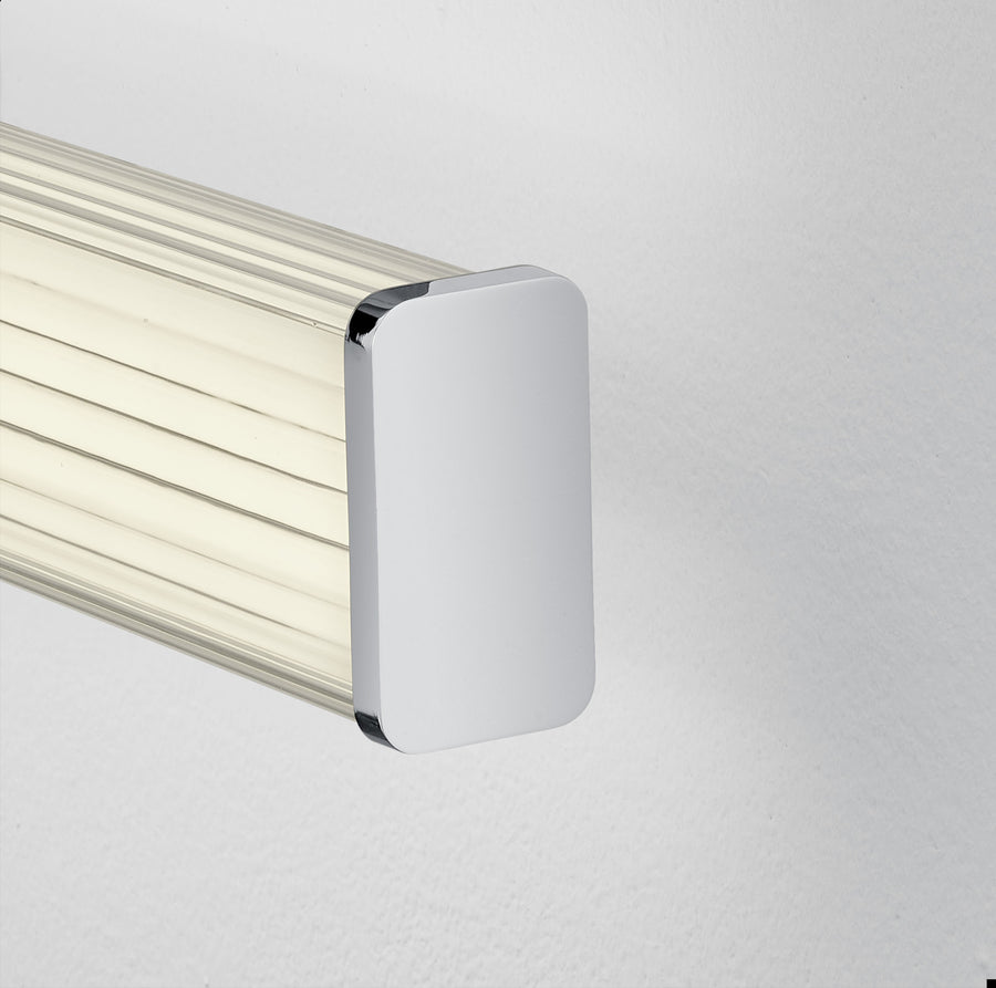 Gros plan sur l'embout chromé brillant et le diffuseur strié du luminaire