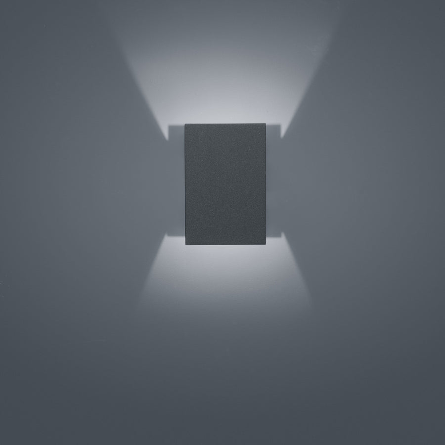 Vue de face, boîtier rectangulaire anthracite projetant deux faisceaux lumineux verticaux