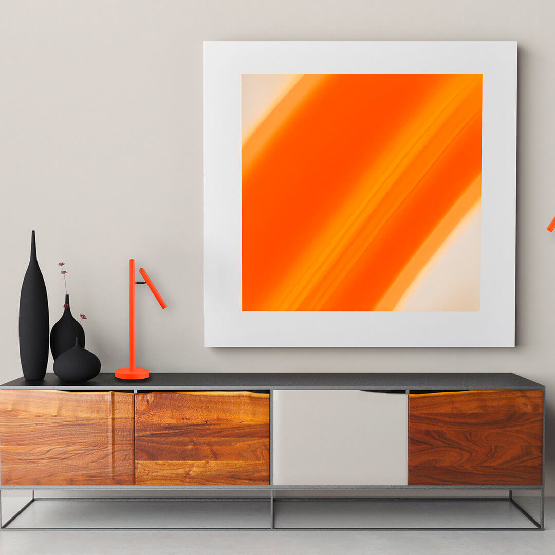 Mise en ambiance dans un salon, lampe orange posée sur un meuble en bois