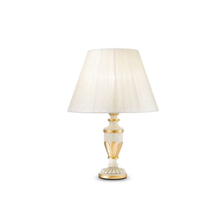 Lampe à poser blanche de face avec abat-jour en tissu plissé et base dorée.