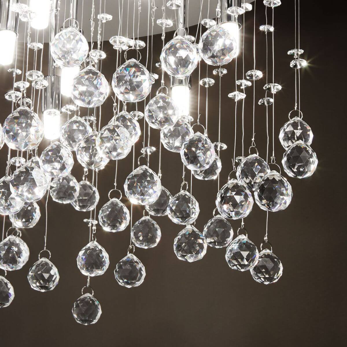 Détail rapproché des boules de cristal taillées et des douilles chromées allumées