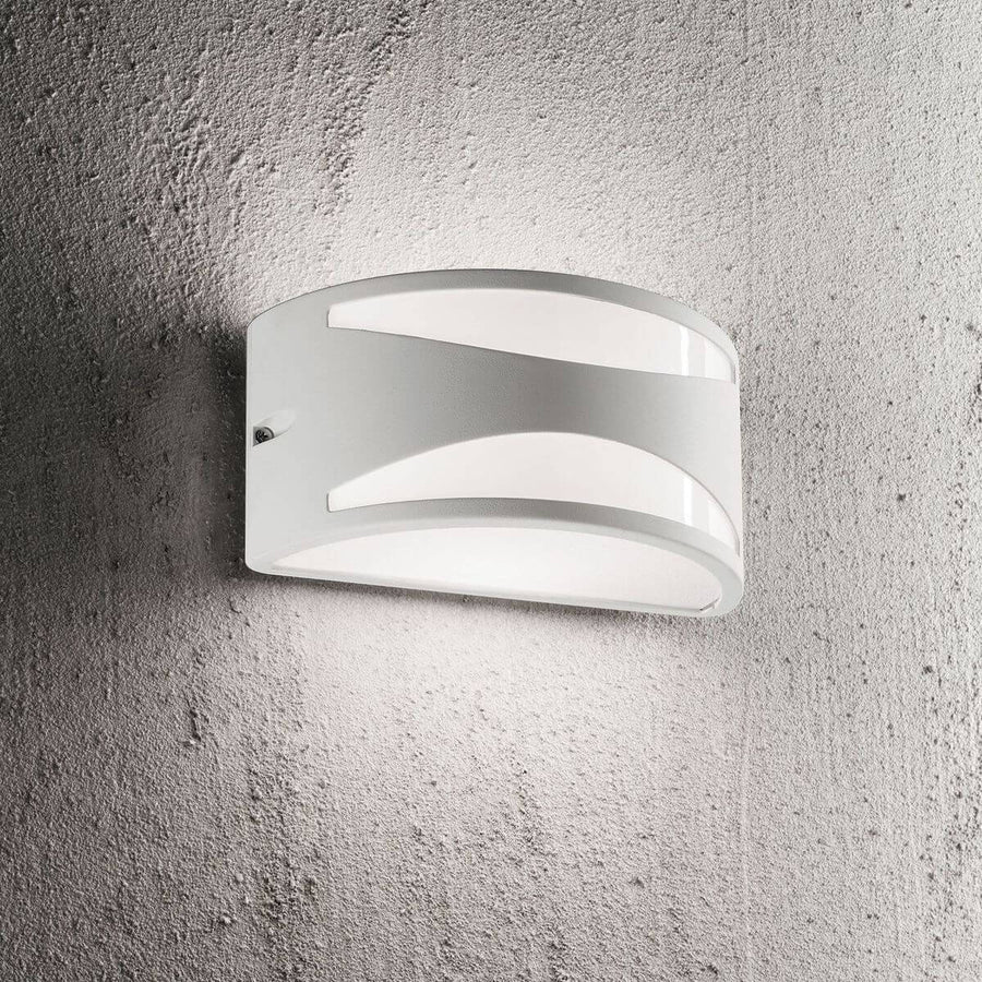 Applique extérieure blanche allumée, fixée sur un mur gris texturé type béton