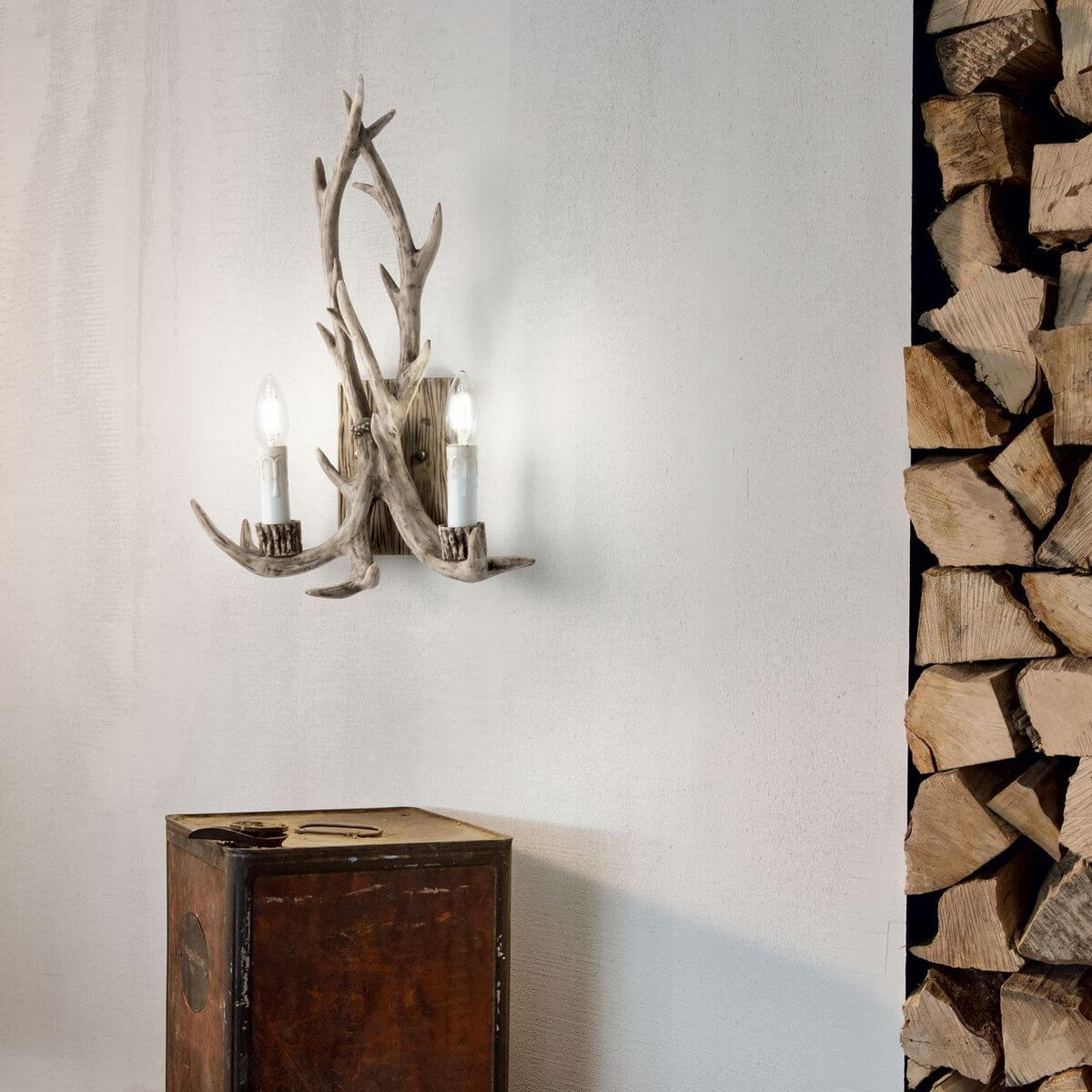 Mise en ambiance sur mur blanc près de bûches, l'applique éclaire une pièce rustique