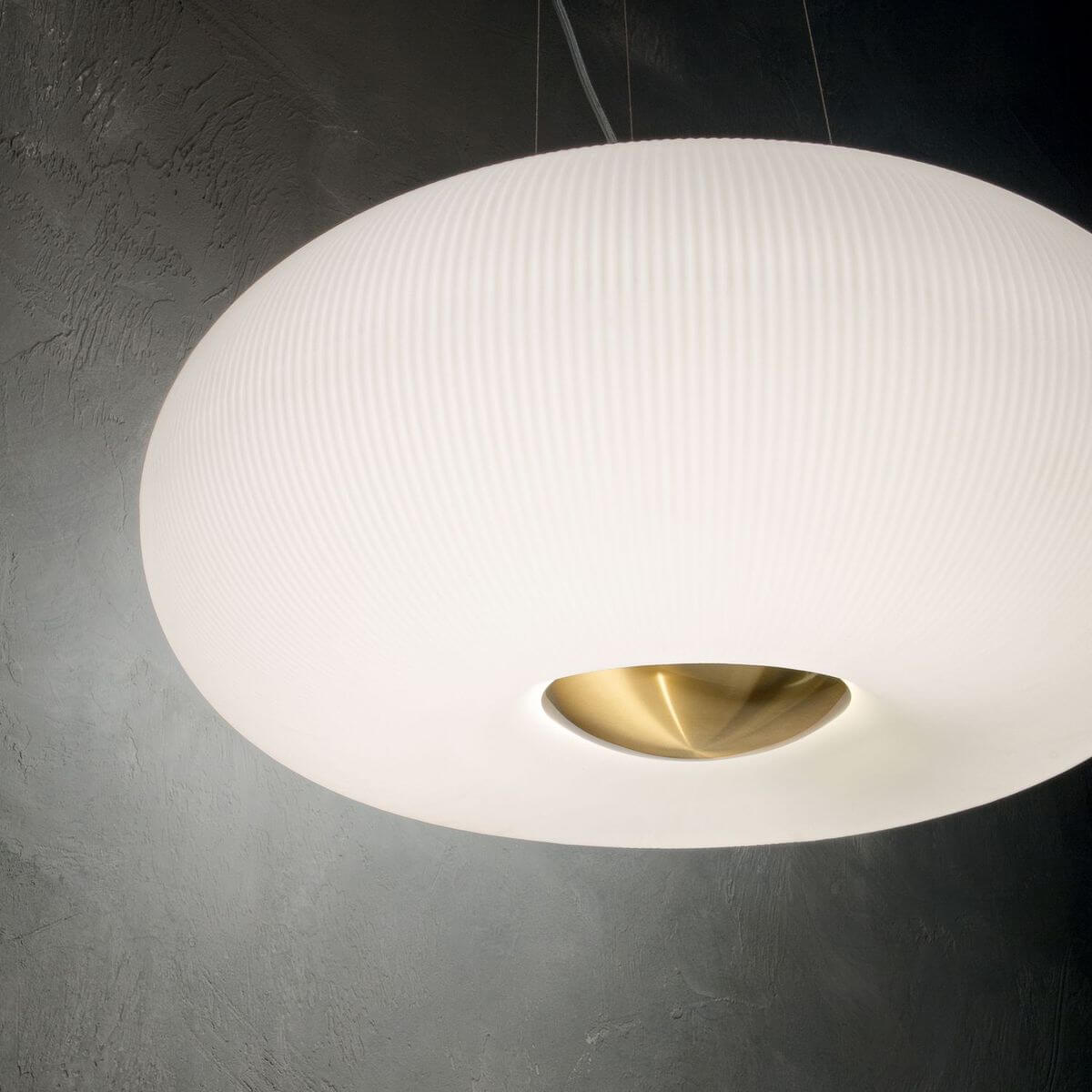 Vue en contre-plongée du luminaire allumé sur un mur gris texturé