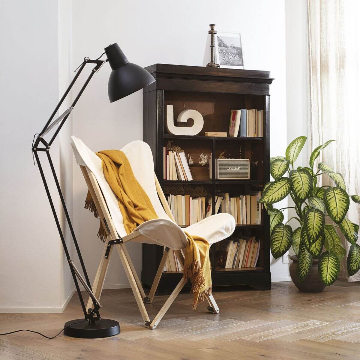 Mise en ambiance du lampadaire noir près d'un fauteuil blanc dans un salon
