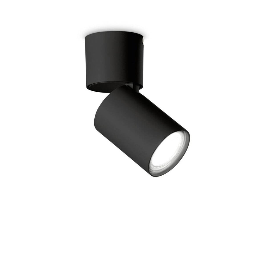 Spot plafonnier noir orientable de face sur fond blanc, tête cylindrique inclinée