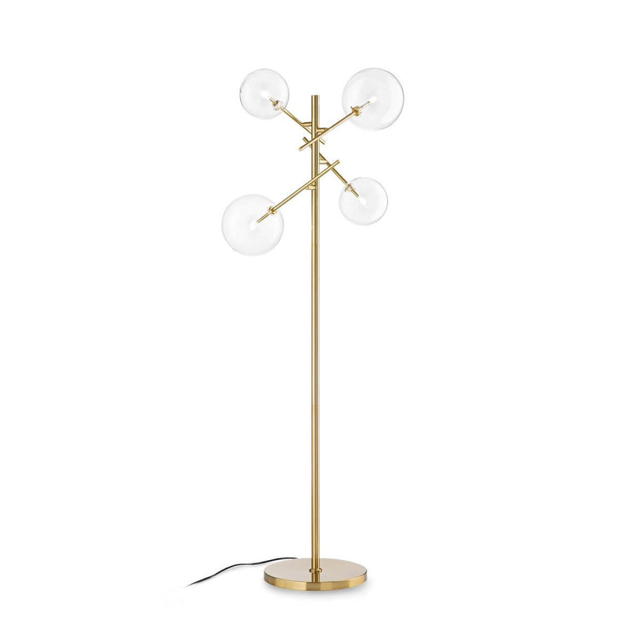 Lampadaire laiton avec quatre globes en verre clair sur bras inclinés, fond blanc.