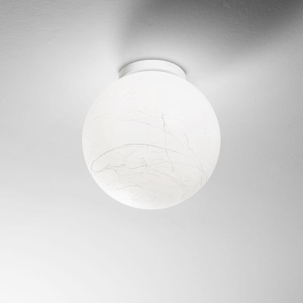 Vue au plafond, sphère blanche allumée au veinage marbré finement dessiné