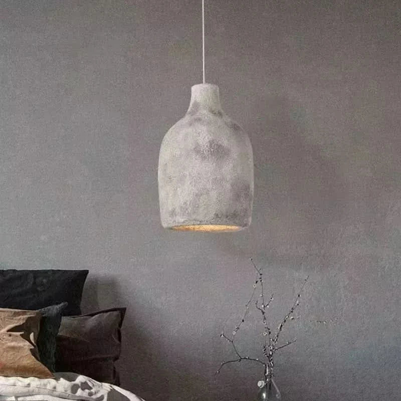 Suspension style pierre grise au-dessus d'un lit, ambiance chambre cosy aux tons gris