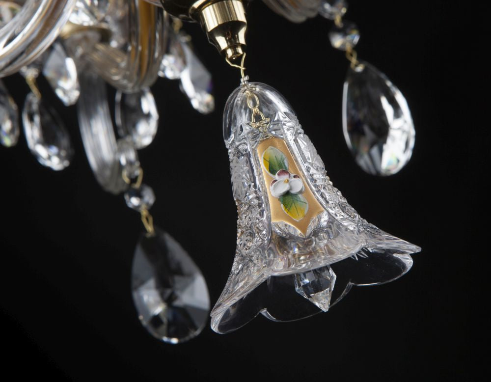 Gros plan sur une clochette de cristal gravée avec motif floral peint
