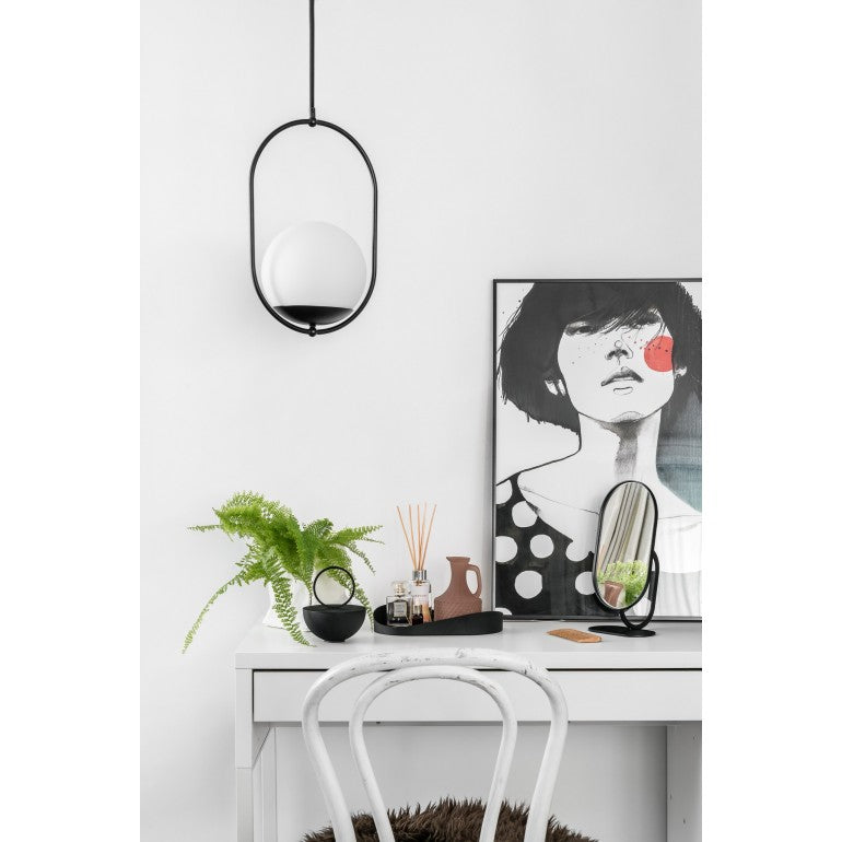 Suspension noire au-dessus d'un bureau, avec plante, parfum d'intérieur et cadre illustré.