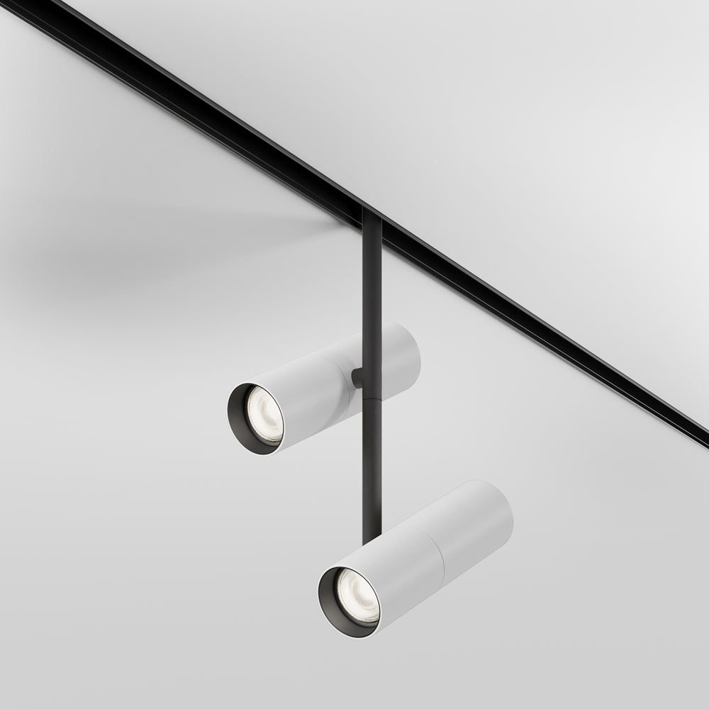 Vue de face du duo de projecteurs cylindriques blancs suspendus au rail noir