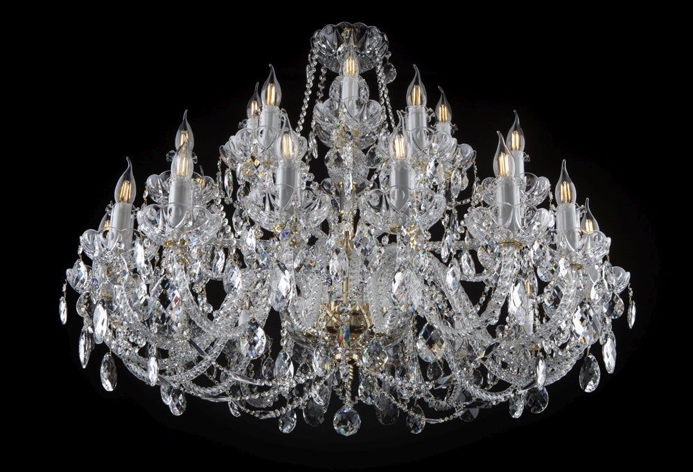 Lustre en cristal de face sur fond noir, bras courbés et pendeloques brillantes