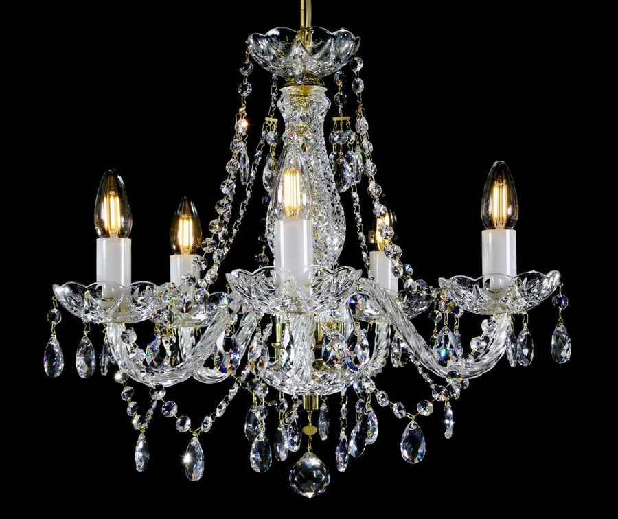 Lustre en cristal à cinq bras, ampoules allumées, suspendu sur fond noir uni