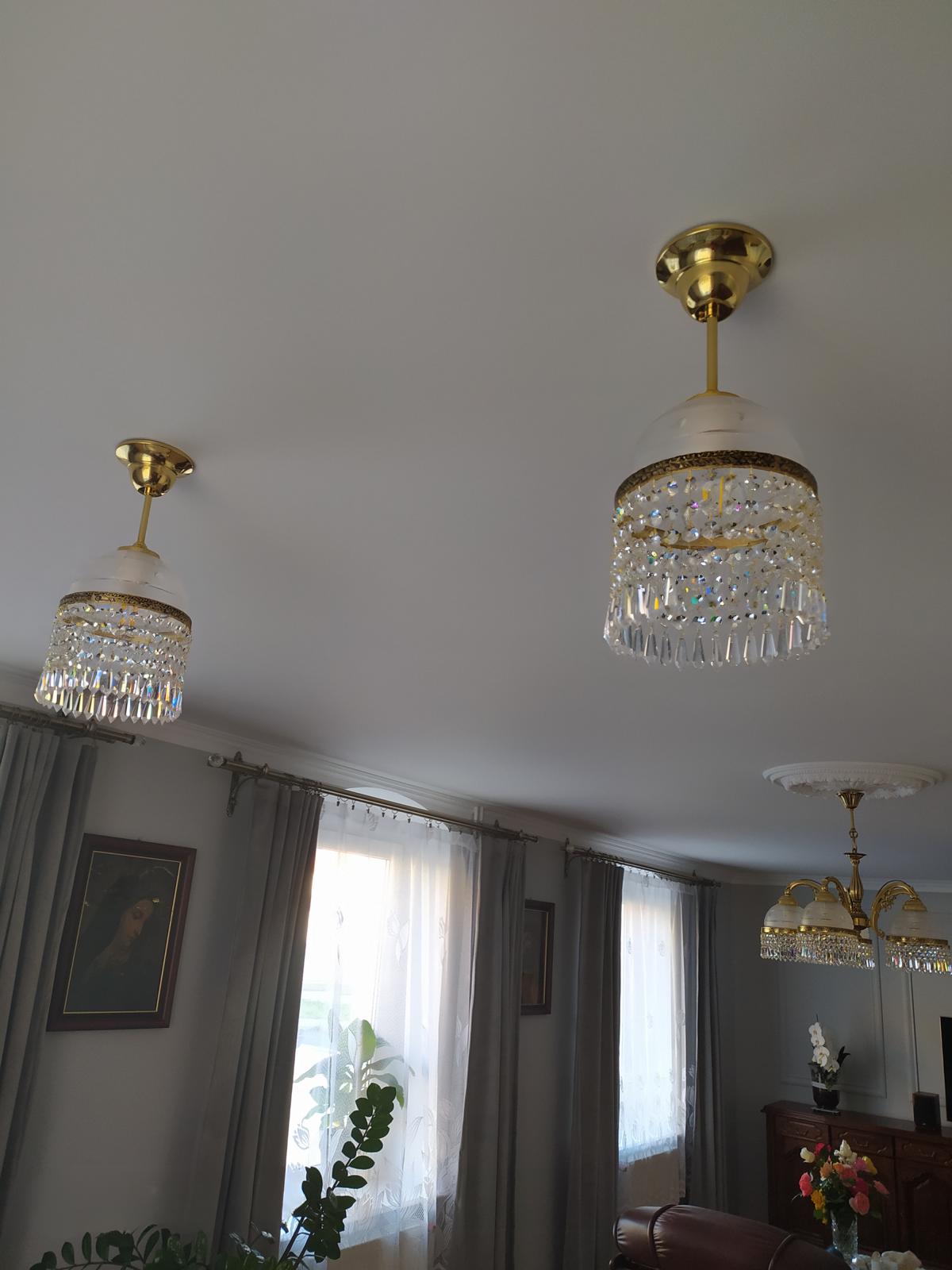 Deux plafonniers vus de dessous dans un salon avec rideaux et fenêtres