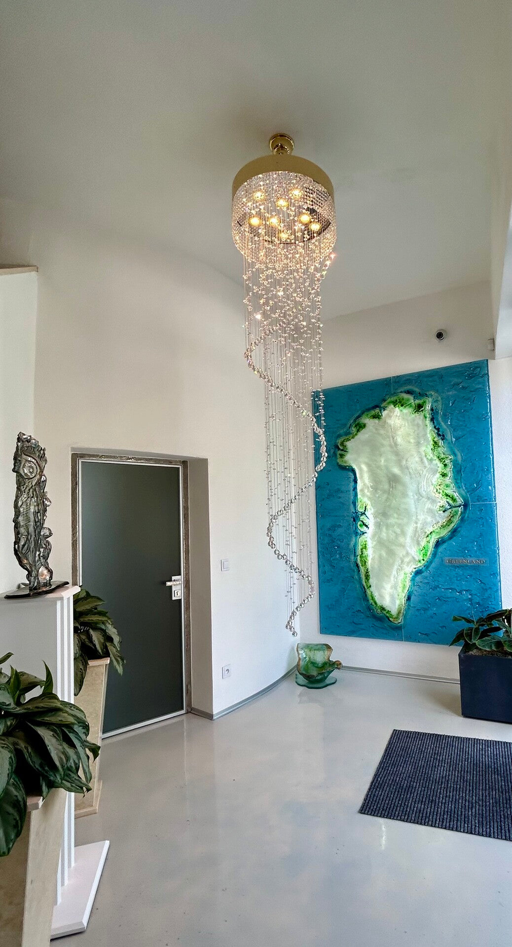 Mise en ambiance dans une entrée, suspension devant une œuvre murale bleue